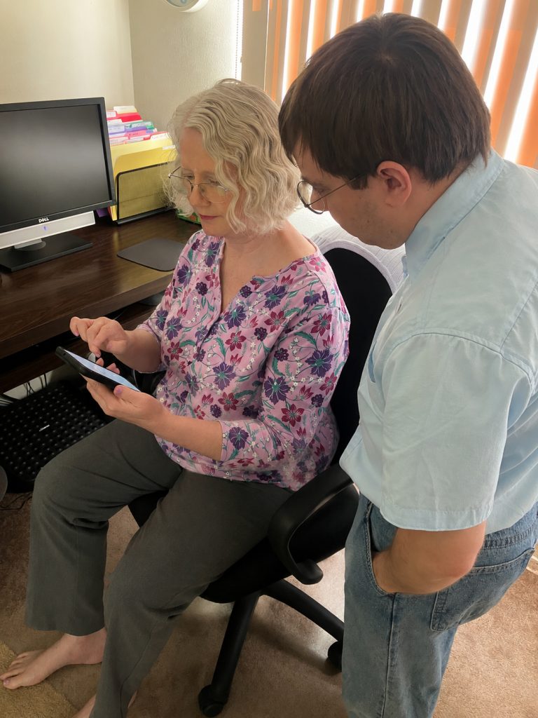 technician helping senior with smartphone setup